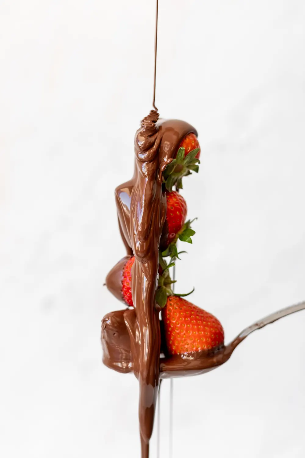 Chocolate pouring over fresh strawberries